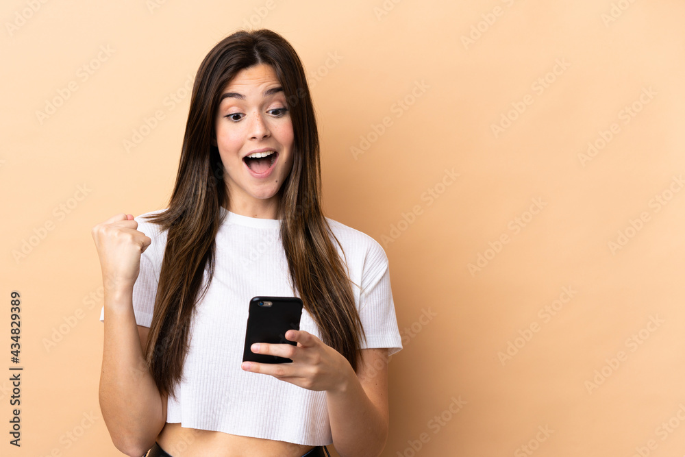 Teenager Brazilian girl over isolated background surprised and sending a message