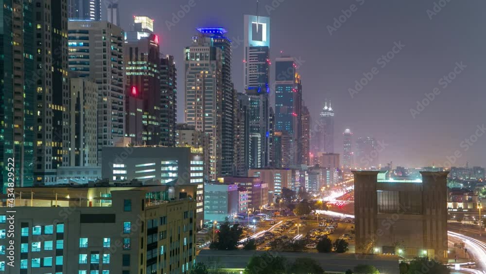 Downtown Dubai towers day to night transition timelapse. Aerial view of Sheikh Zayed road with skyscrapers after sunset. Traffic on the road and parking lot Downtown Dubai towers day to night transition timelapse. Aerial view of Sheikh Zayed road with skyscrapers after sunset. Traffic on the road and parking lot