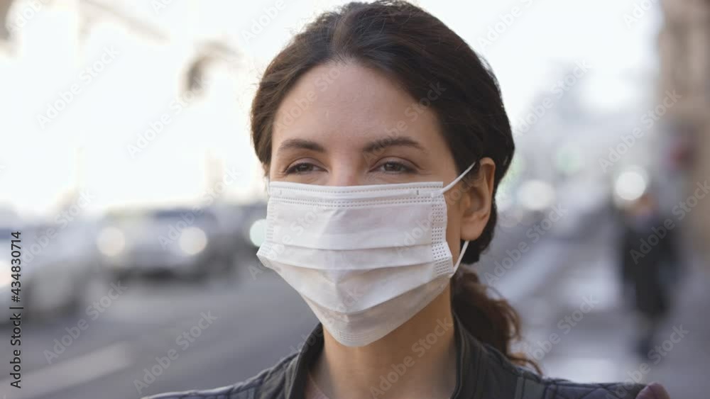 Young woman in medical mask close up face portrait city street day light Young woman in medical mask close up face portrait city street day light