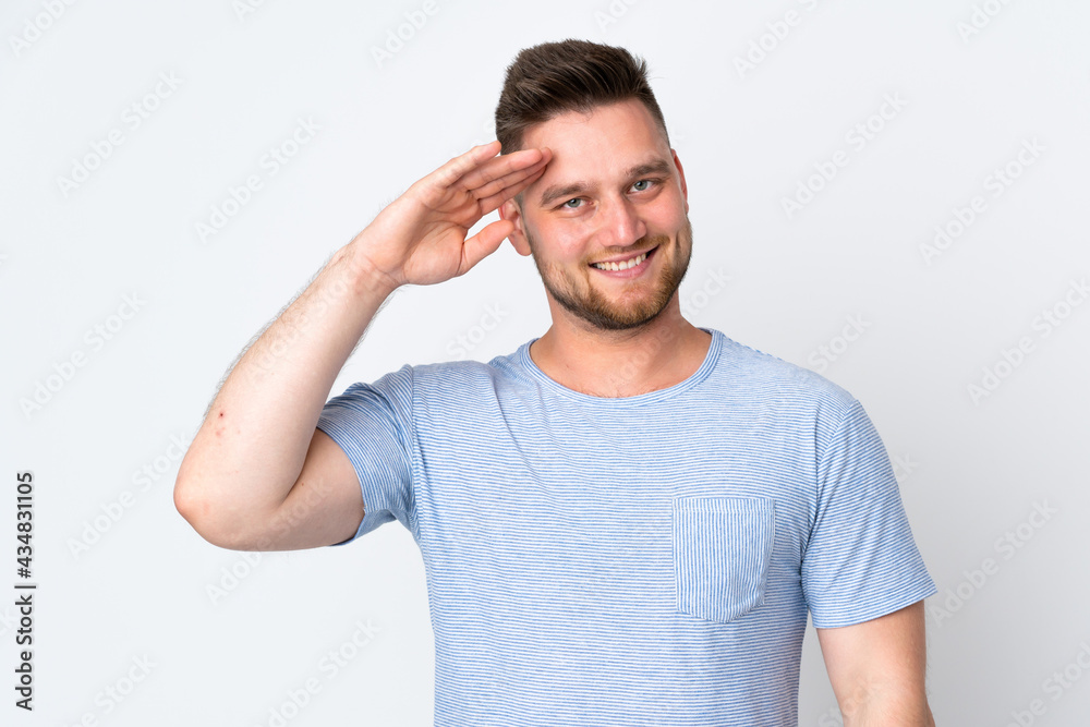 Russian handsome man over isolated background saluting with hand with happy expression