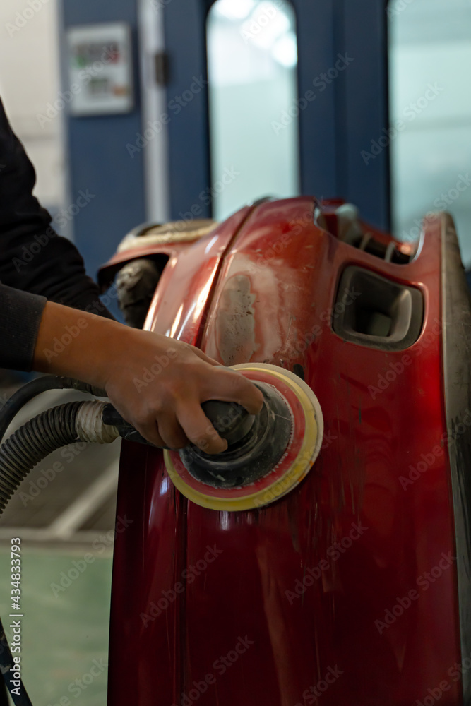 Man machine sands a customer's bumper. Madrid