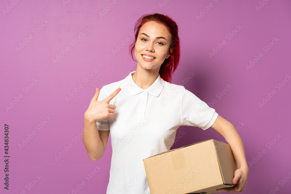 Teenager delivery girl isolated on purple background giving a thumbs up gesture