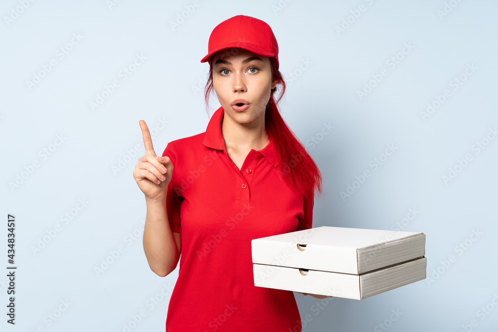 Pizza delivery girl holding a pizza over isolated background intending to realizes the solution while lifting a finger up Pizza delivery girl holding a pizza over isolated background intending to realizes the solution while lifting a finger up