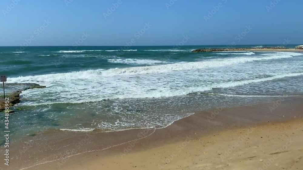 Sandy beach on a sunny day at the sea. Tide waves on the ocean on a warm vacation day. Relaxation and a beautiful view of nature. Wave and vacation. HD Sandy beach on a sunny day at the sea. Tide waves on the ocean on a warm vacation day. Relaxation and a beautiful view of nature. Wave and vacation. HD
