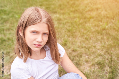 Little girl portrait. Outdoor green background. Looking. Teenager schoolgirl at park. Cute face. Children beauty. Female head. Charisma caucasian © elenavolf