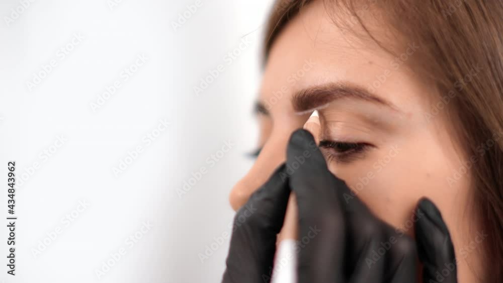 Closeup woman cosmetologist improving correcting eyebrows drawing shape use pencil microblading Closeup woman cosmetologist improving correcting eyebrows drawing shape use pencil microblading