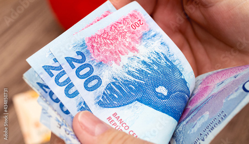 Photos Uma pessoa contando cédulas do dinheiro da Argentina, que é o Peso Argentino - ARS