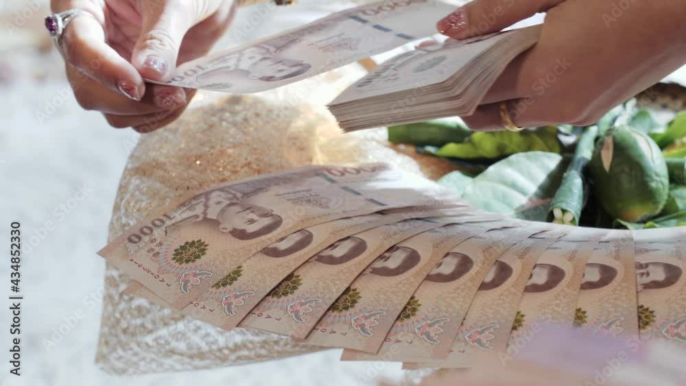 Brand new banknotes beautifully and gently arranged around the bridewealth tray during traditional Thai wedding ceremony. Thai Baht, currency themes.