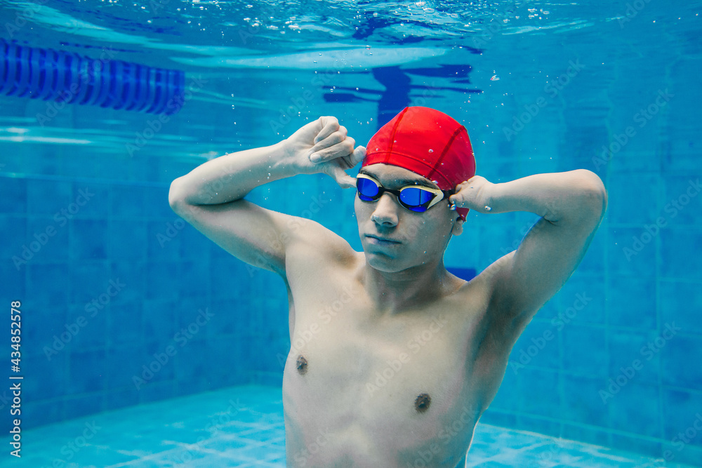 portrait of paralympic Swimmer young mexican man Underwater Training In Pool with hand hypoplasia in disability concept