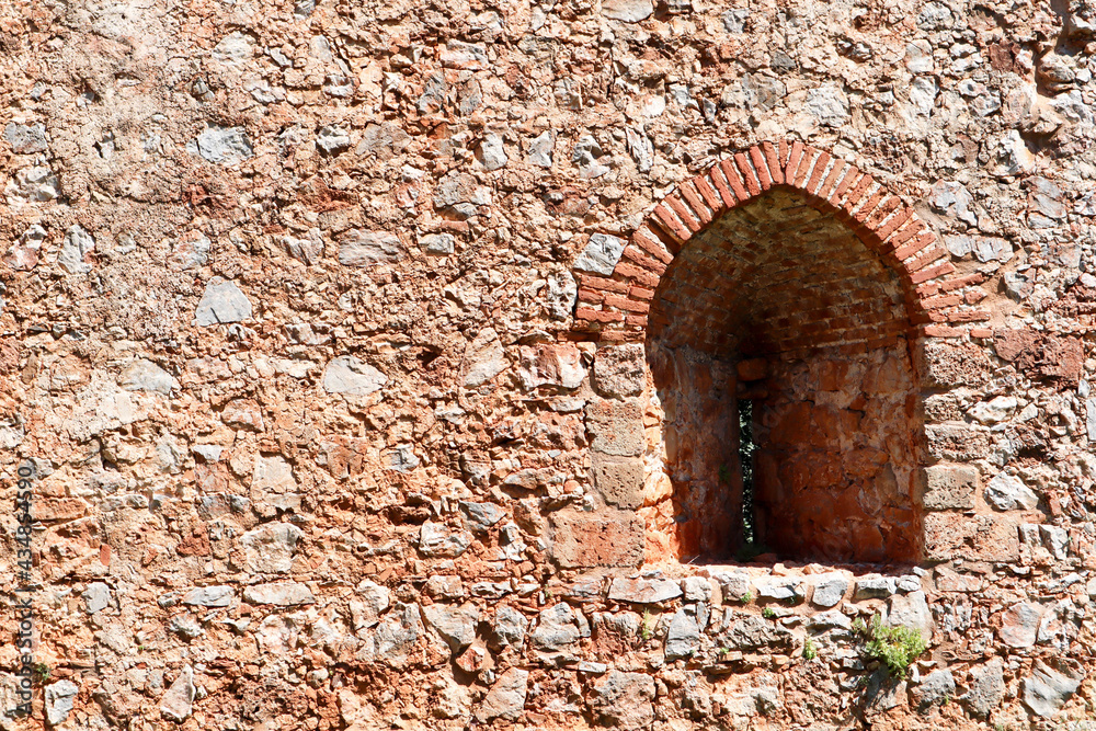 old fortress red brick stone wall with the arch window close up