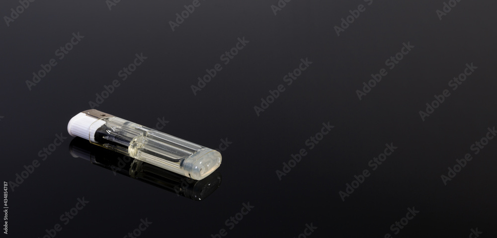 A white gas lighter on a black reflecting background - copy space A white gas lighter on a black reflecting background - copy space