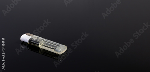 A white gas lighter on a black reflecting background - copy space
