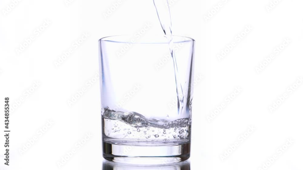 Water being poured into Glass against White Background. Isolated conceptual footage Water being poured into Glass against White Background. Isolated conceptual footage