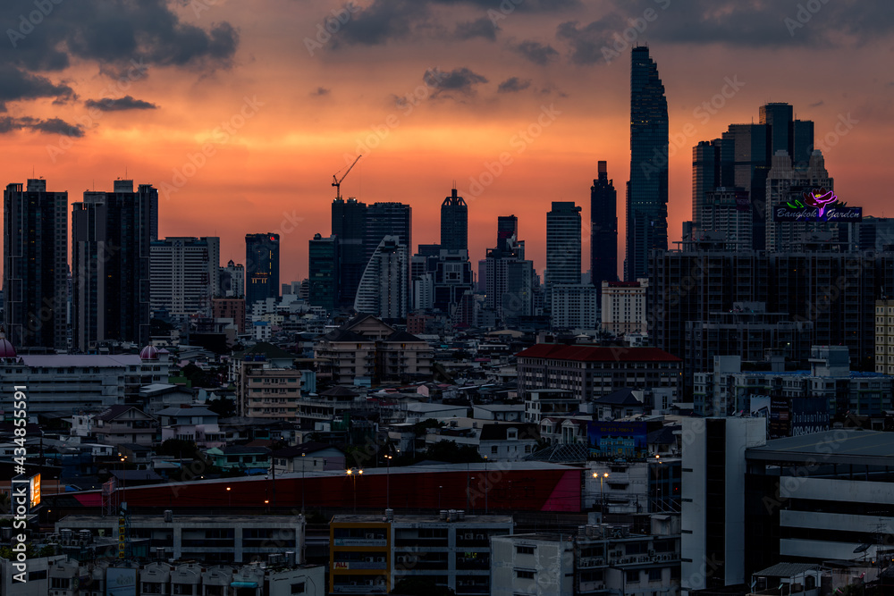 Fototapeta premium The high angle background of the city view with the secret light of the evening, blurring of night lights, showing the distribution of condominiums, dense homes in the capital community