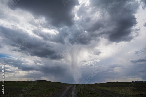 tornado in stormy sky over dirt road in mongolia