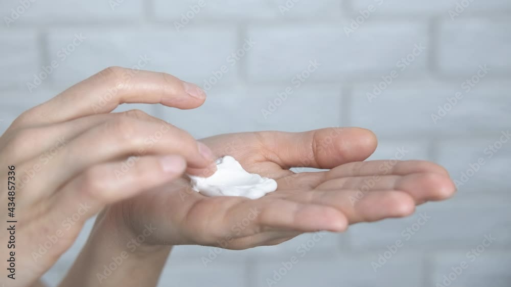 Beauty lotion on hands. A woman use a beauty softening cream for her hands in the room. Beauty lotion on hands. A woman use a beauty softening cream for her hands in the room.