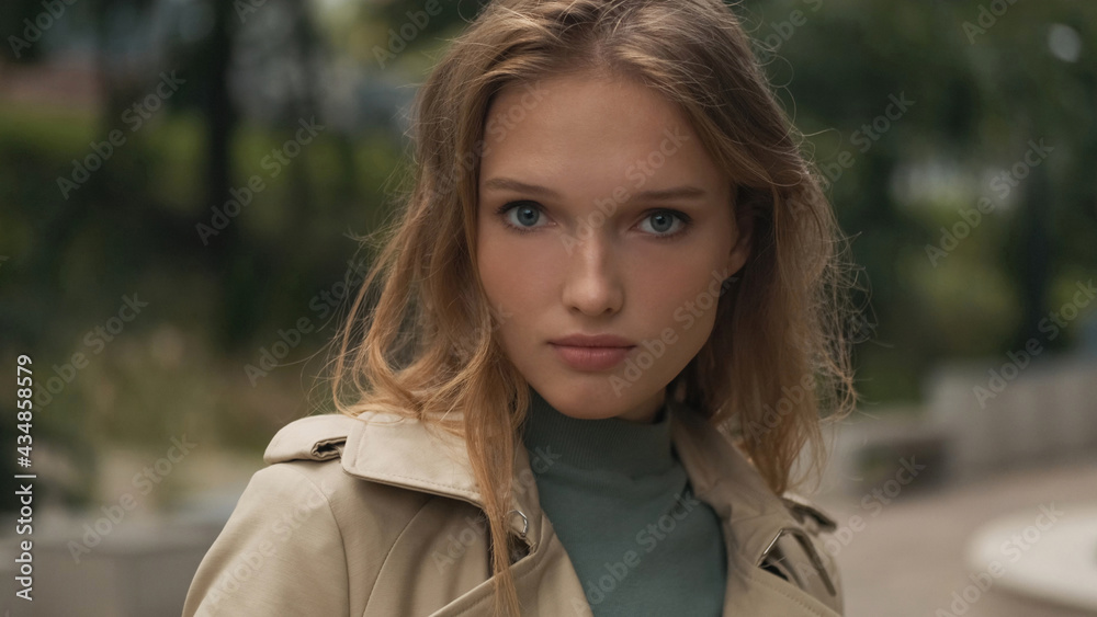 Beautiful blond girl looking straightly in camera walking throug Beautiful blond girl looking straightly in camera walking throug