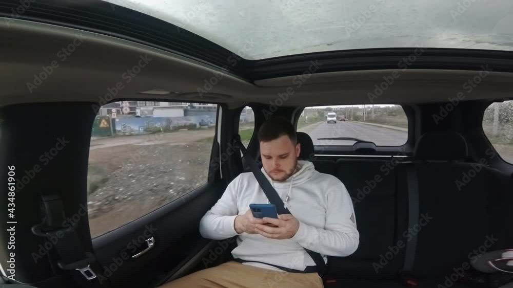 man sitting at rear car sits looking in window man sitting at rear car sits looking in window