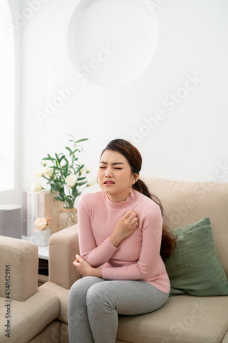 asian beauty woman has dry skin and scratching her elbow in the living room