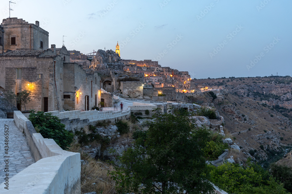 Evening view of the city of Matera; Italy; with the colorful lights highlighting old buildings in the Sassi di Matera a historic district in the city of Matera. Basilicata. Italy
