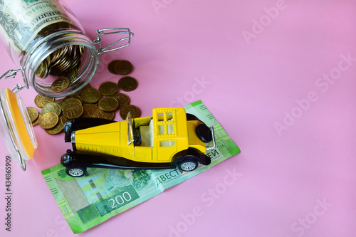 yellow toy car on the banknote and manets. concept of auto insurance and finance for the purchase of a car photo