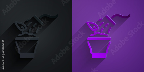 Paper cut Spraying a house plant with a spray gun icon isolated on black on purple background. Moistening of foliage. Care for home flowers. Paper art style. Vector