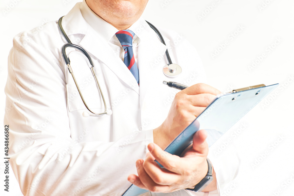 Doctor standing and working with clipboard on patient history records in clinic Doctor standing and working with clipboard on patient history records in clinic