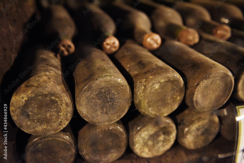 Yalta, Crimea - 10.16.2015 : Wine bottles from the 1940s covered in dust are laid out in the old cellar of the winery. Yalta, Crimea - 10.16.2015 : Wine bottles from the 1940s covered in dust are laid out in the old cellar of the winery.