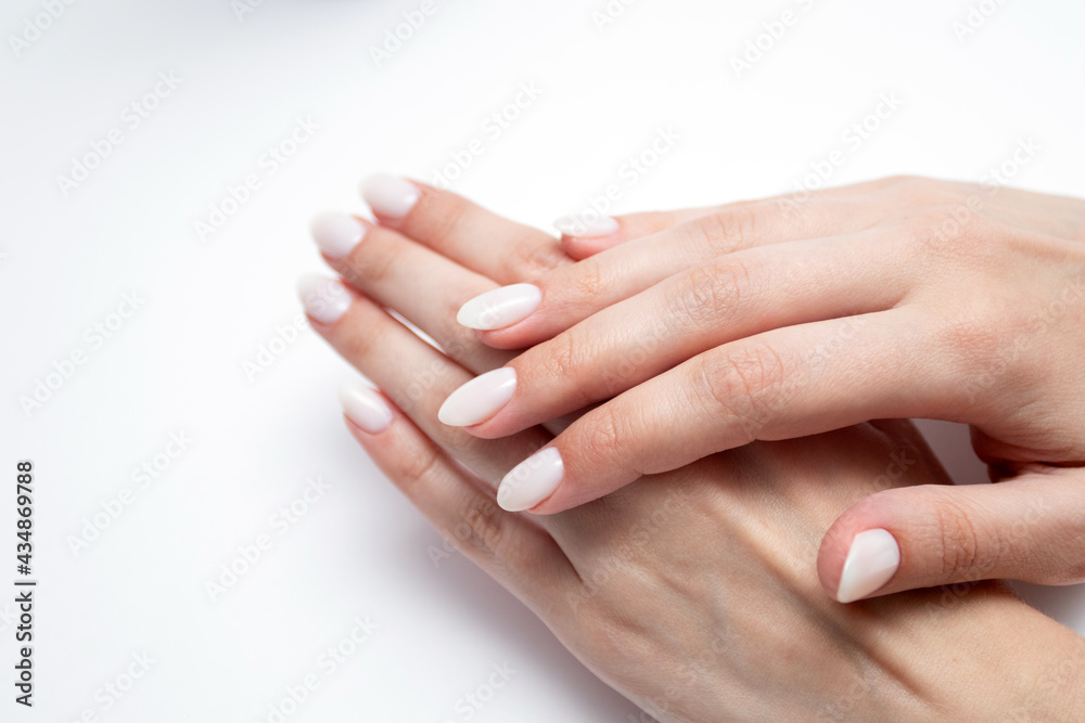 Woman's hands with professional manicure in beige colors Woman's hands with professional manicure in beige colors