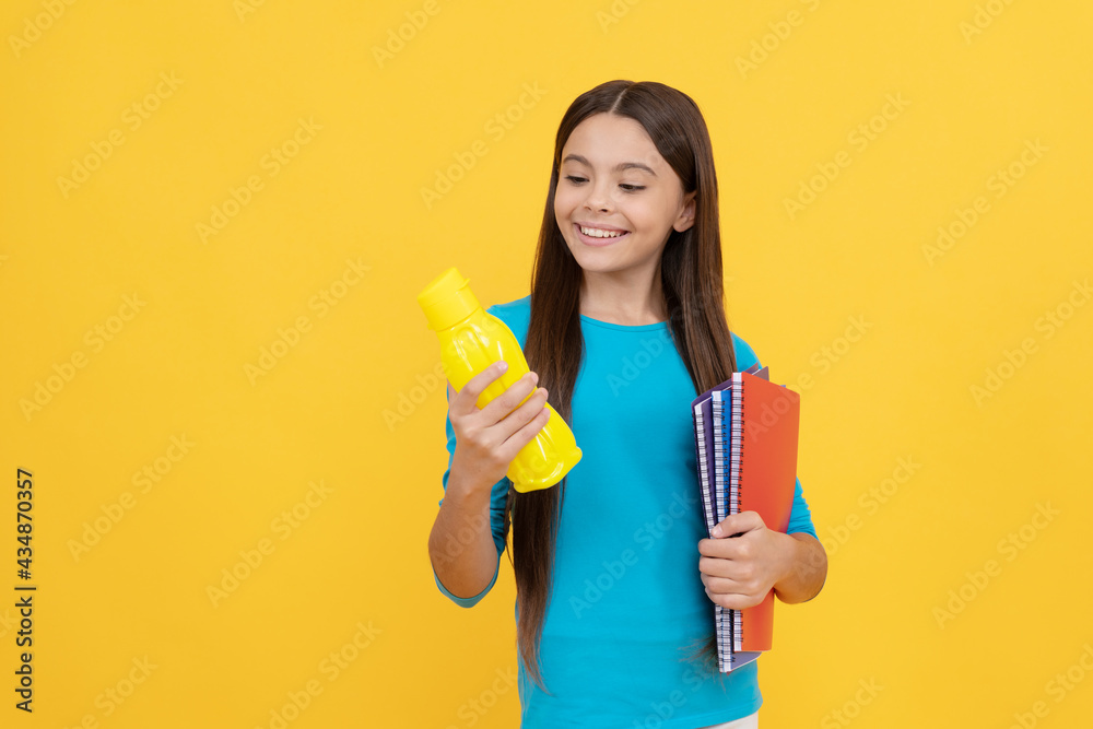 going to drink. cheerful kid with juice or water and books. smiling teenager student. going to drink. cheerful kid with juice or water and books. smiling teenager student.