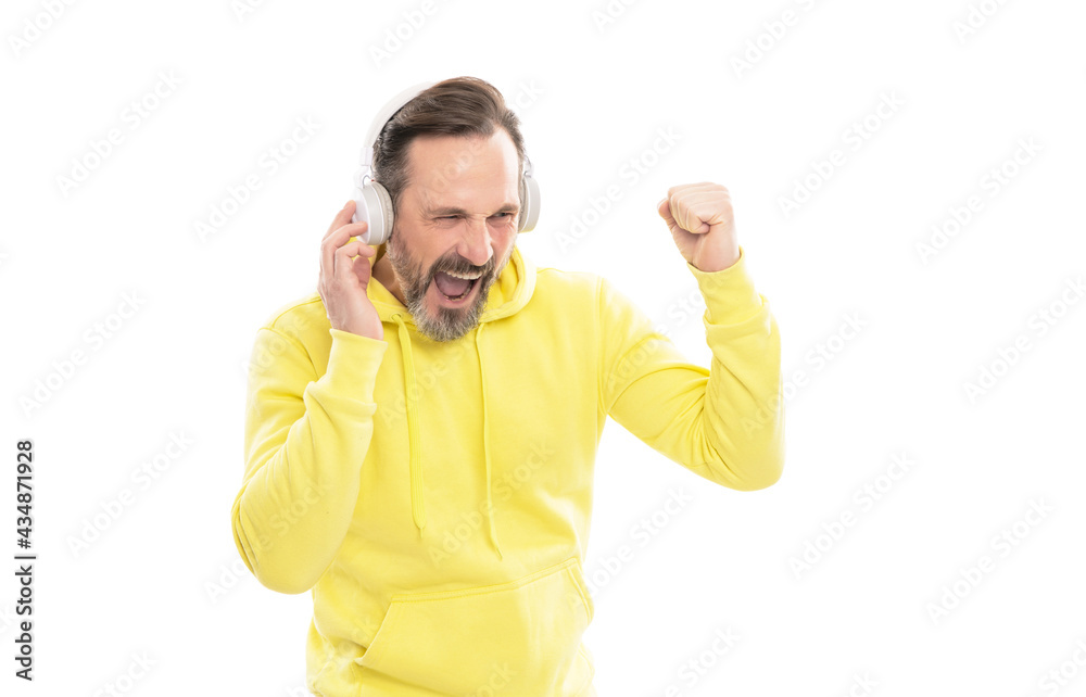 Naklejka premium cheerful mature man in hoody listen music or audio book in headphones isolated on white, music.