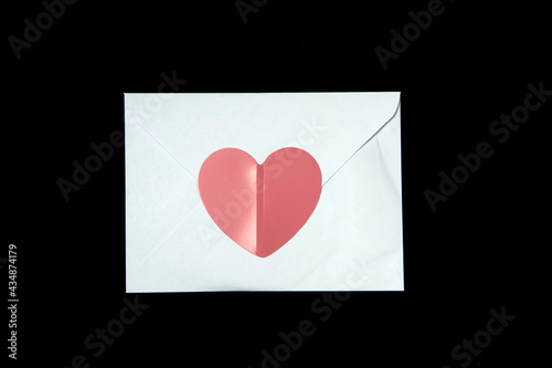 An envelope with a heart on a black background.