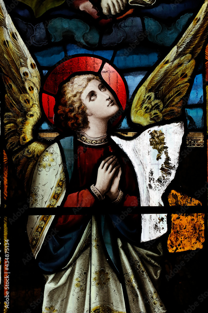 Stained glass window. Angel praying.