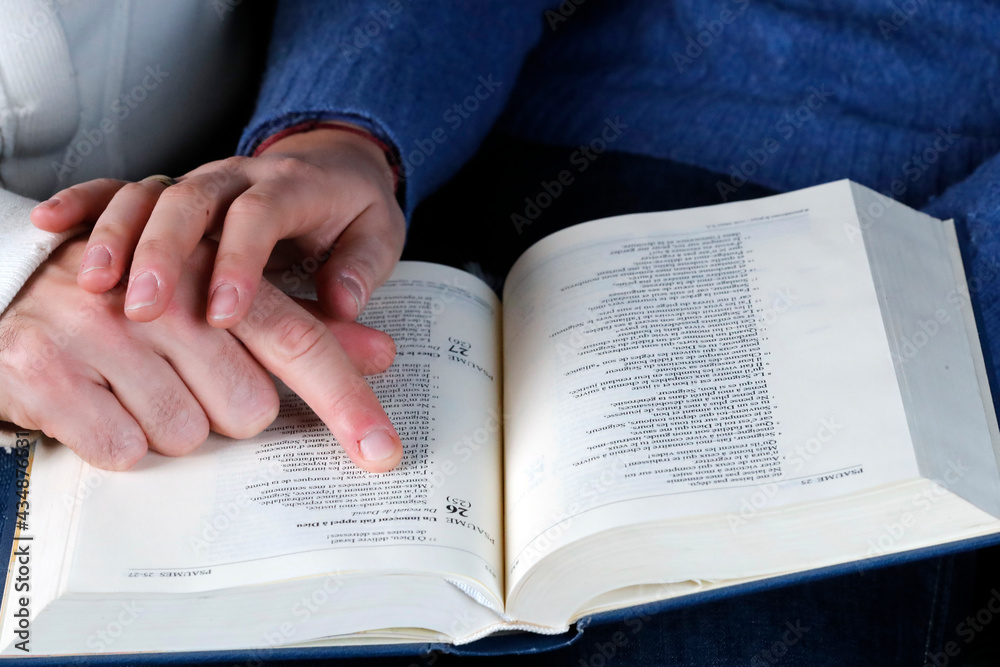 Man and woman reading together the bible at home. Christian couple living in the love of God and Jesus. France. Man and woman reading together the bible at home. Christian couple living in the love of God and Jesus. France.