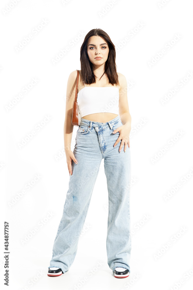 Lovely feminine young woman in summer clothes with handbag posing at camera. Full body length isolated on white background Lovely feminine young woman in summer clothes with handbag posing at camera. Full body length isolated on white background