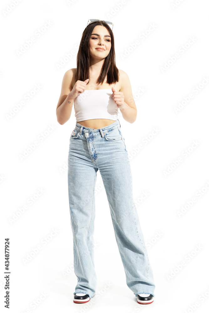 Happy summer girl in street style clothes dancing to music looking away. Full body length isolated on white background Happy summer girl in street style clothes dancing to music looking away. Full body length isolated on white background