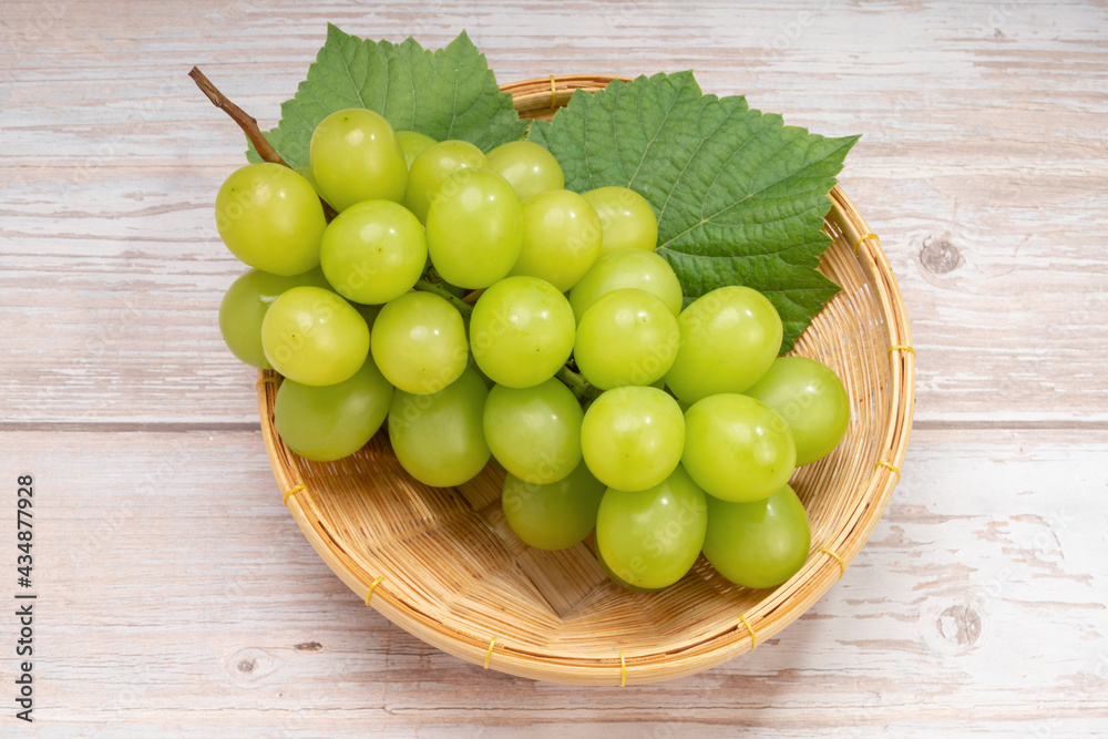 Japanese Shine Muscat Grape in basket on wooden Background, Sweet Green grape on wooden background. Japanese Shine Muscat Grape in basket on wooden Background, Sweet Green grape on wooden background.
