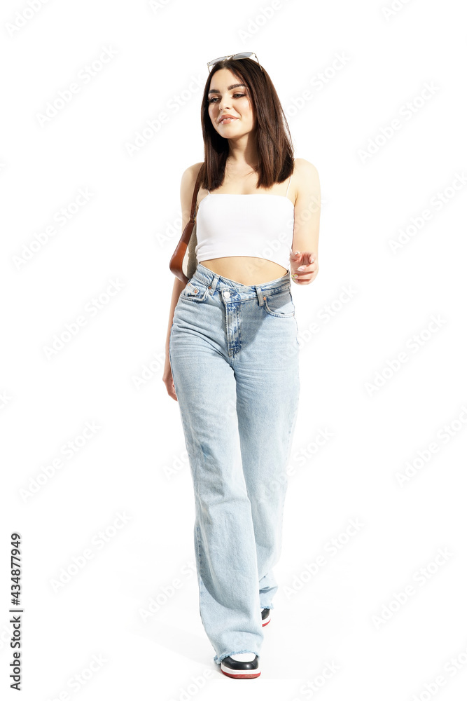 Confident trendy summer street style woman walking and looking away. Full body length isolated on white background Confident trendy summer street style woman walking and looking away. Full body length isolated on white background