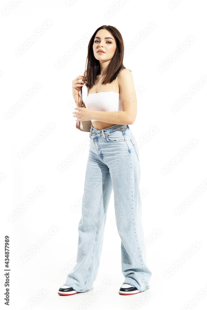 Side view of trendy young generation Z girl put on handbag on shoulder. Full body length isolated on white background Side view of trendy young generation Z girl put on handbag on shoulder. Full body length isolated on white background