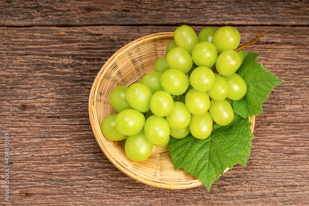 Japanese Shine Muscat Grape in basket on wooden Background, Sweet Green grape on wooden background. Japanese Shine Muscat Grape in basket on wooden Background, Sweet Green grape on wooden background.