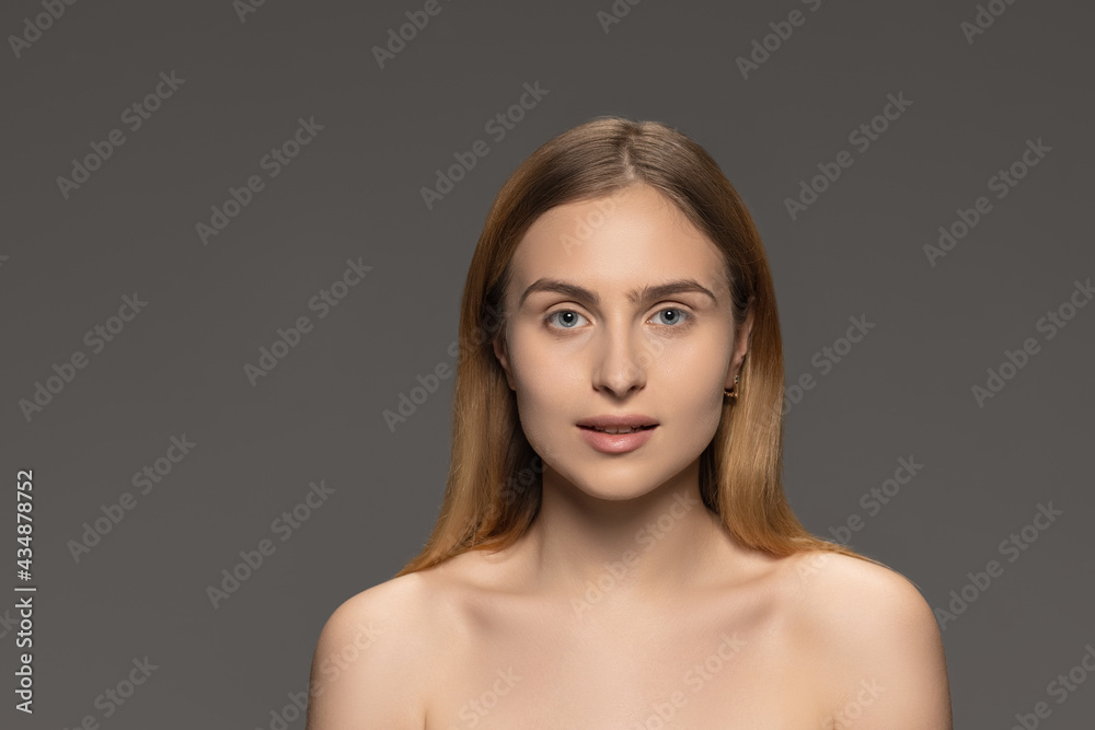 Portrait of young female fashion model isolated on grey studio background. Beautiful caucasian woman with well-kept skin. Portrait of young female fashion model isolated on grey studio background. Beautiful caucasian woman with well-kept skin.