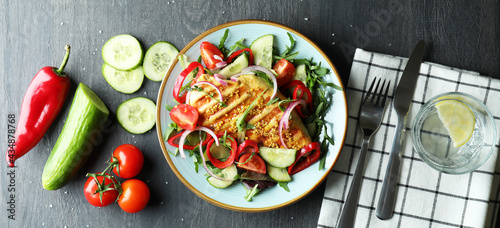 Concept of tasty eating with salad with grilled chicken on dark textured table