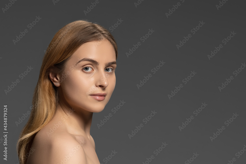 Portrait of young female fashion model isolated on grey studio background. Beautiful caucasian woman with well-kept skin. Portrait of young female fashion model isolated on grey studio background. Beautiful caucasian woman with well-kept skin.