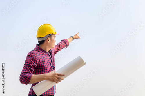 Engineer man checking and planning project at the construction site, Man holding blueprint and pointing into the sky