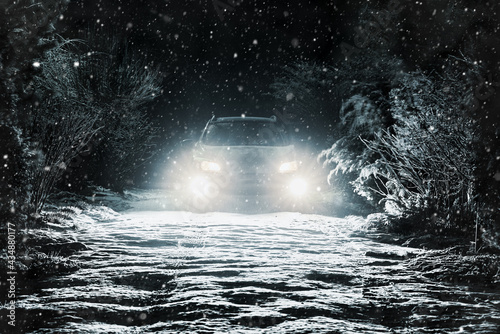 Snow falls on the road in the headlights