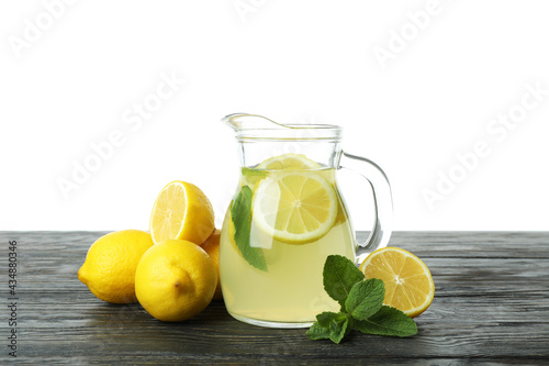 Jug of lemonade on wooden table isolated on white background