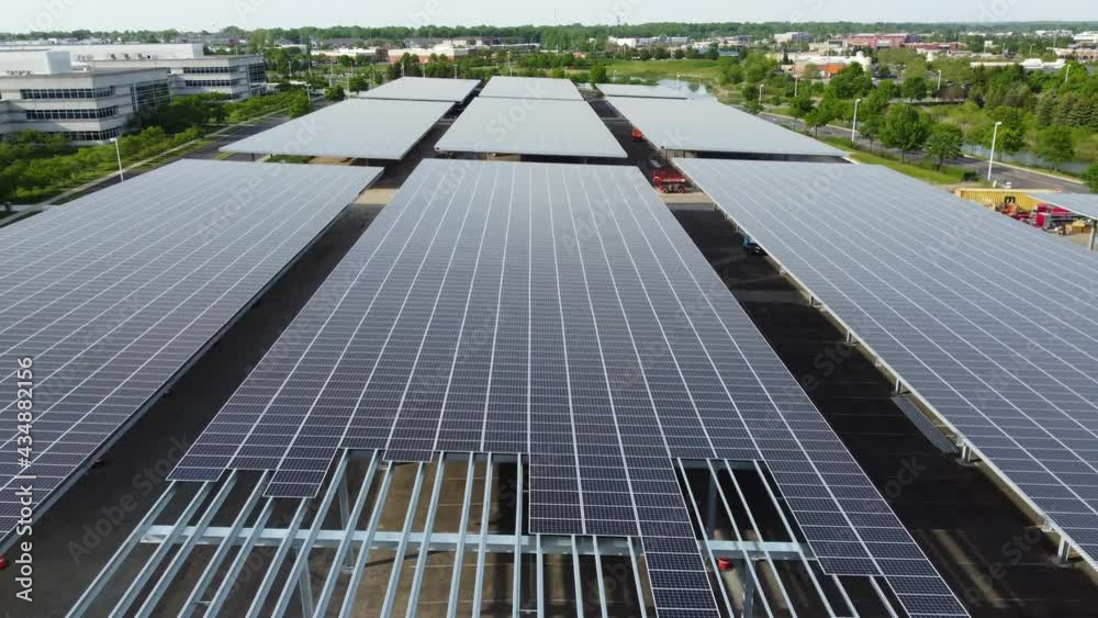 Solar panels installed in a corporate office complex parking lot and solar panels on the office complex buildings. A massive solar panel installation. Solar panels installed in a corporate office complex parking lot and solar panels on the office complex buildings. A massive solar panel installation.