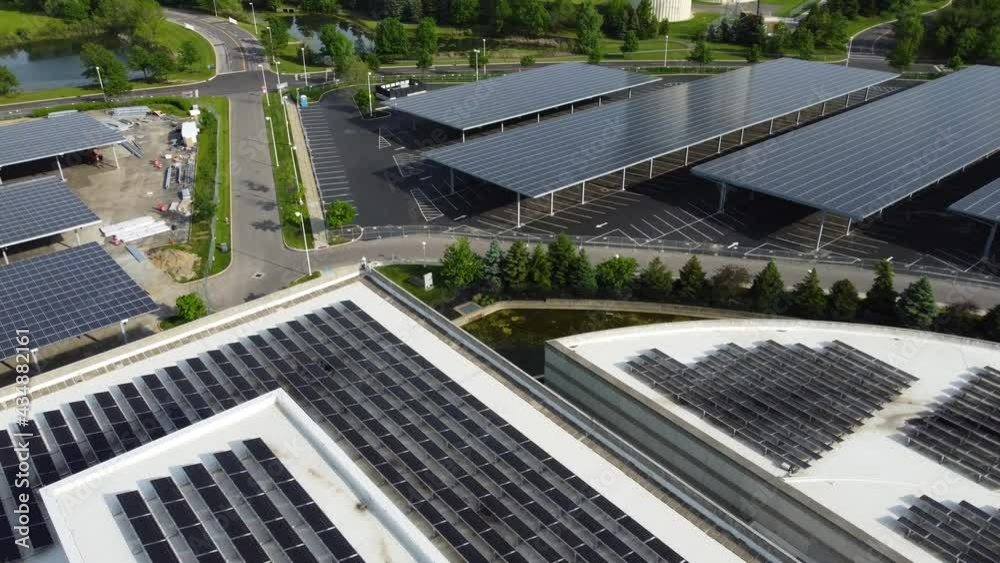 Solar panels installed in a corporate office complex parking lot and solar panels on the office complex buildings. A massive solar panel installation. Solar panels installed in a corporate office complex parking lot and solar panels on the office complex buildings. A massive solar panel installation.