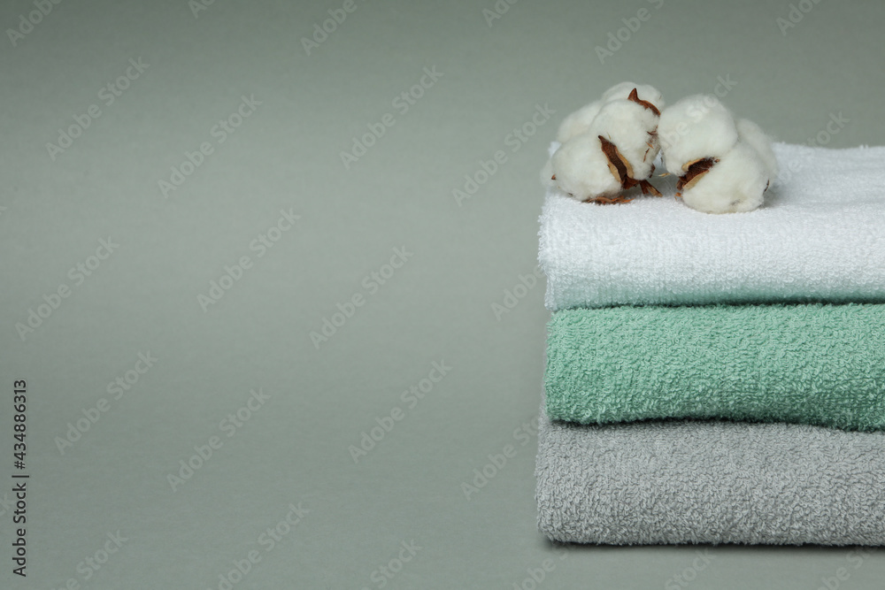 Clean folded towels with cotton on gray background Clean folded towels with cotton on gray background