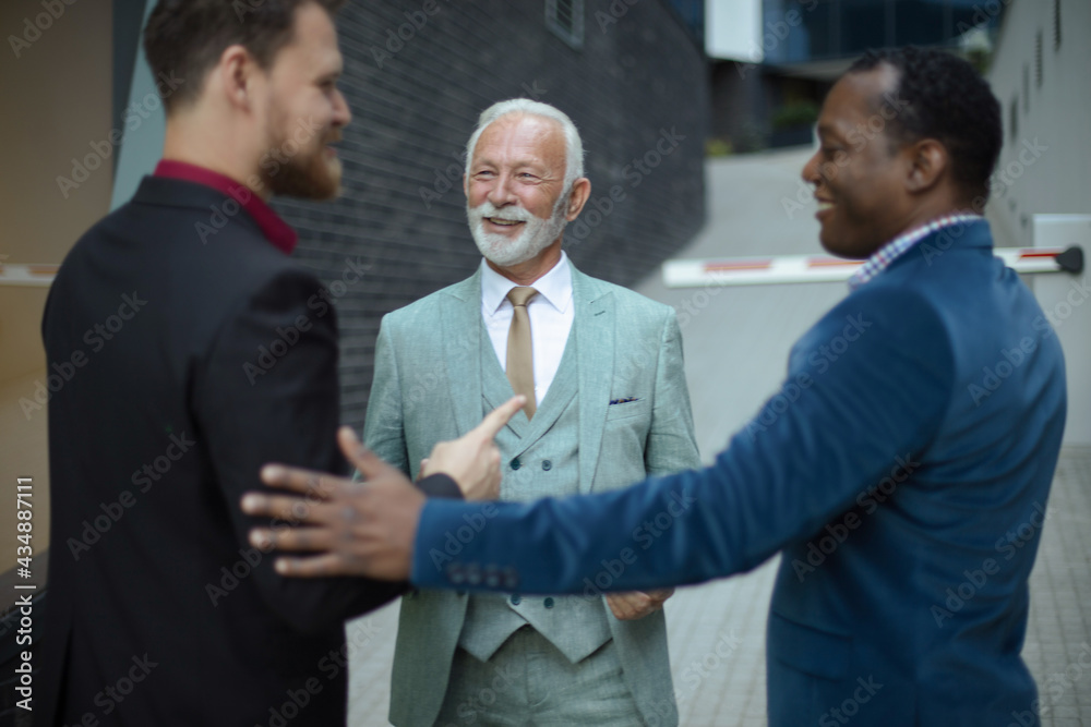 Three business men talking. Focus is on senior man.